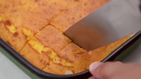 slicing corn pie in the baking tray closeup look