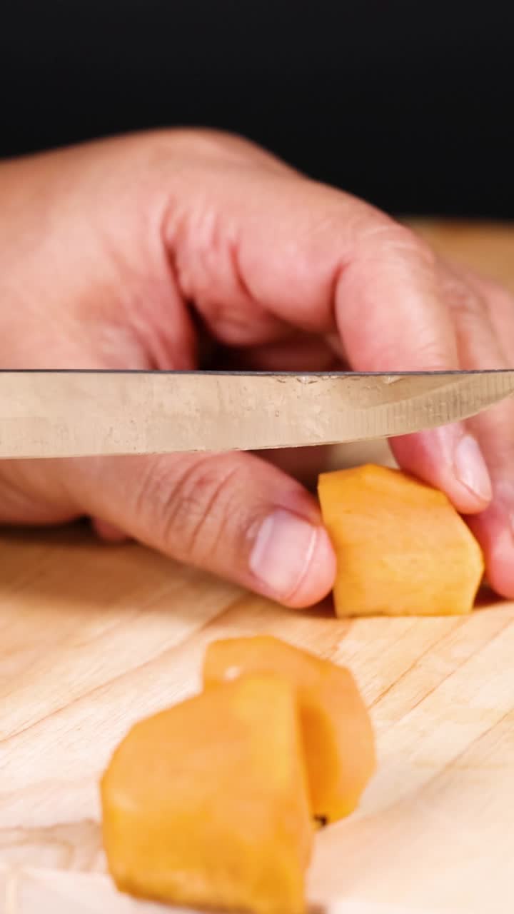 manos cortando cuidadosamente el caqui con un cuchillo