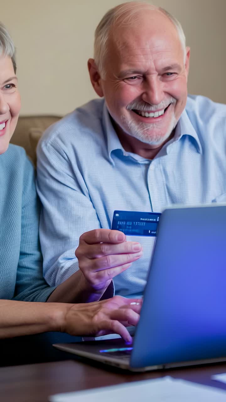 Vídeo vertical: personas mayores de azul tecleando los datos de la tarjeta en un portátil en casa tras un prompt de confirmación de compra, pagando