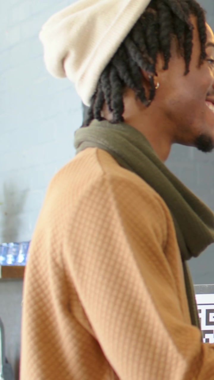Video verticale: Inquadratura che si allarga su un uomo con maglione color cammello appoggiato al terminale POS che paga tramite QR, con spazio per il testo