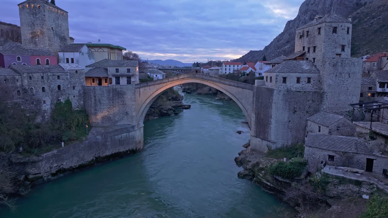 Ripresa aerea del ponte Stari Most che si fonde nel paesaggio crepuscolare