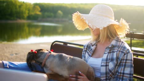 young woman relaxing on bench with her dog