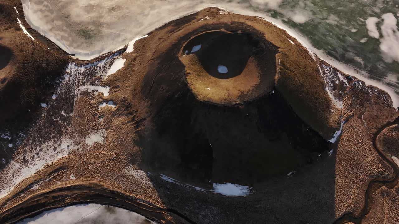 Aerial view of frozen Lake Mývatn with Skútustaðir's distinct pseudocraters under golden light. Reykjahlíð, Iceland