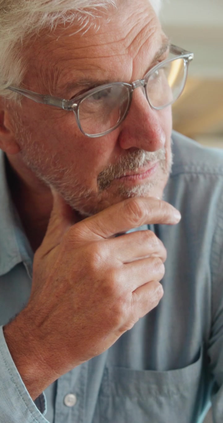 Thoughtful Senior Man With Glasses Resting Chin On Hand