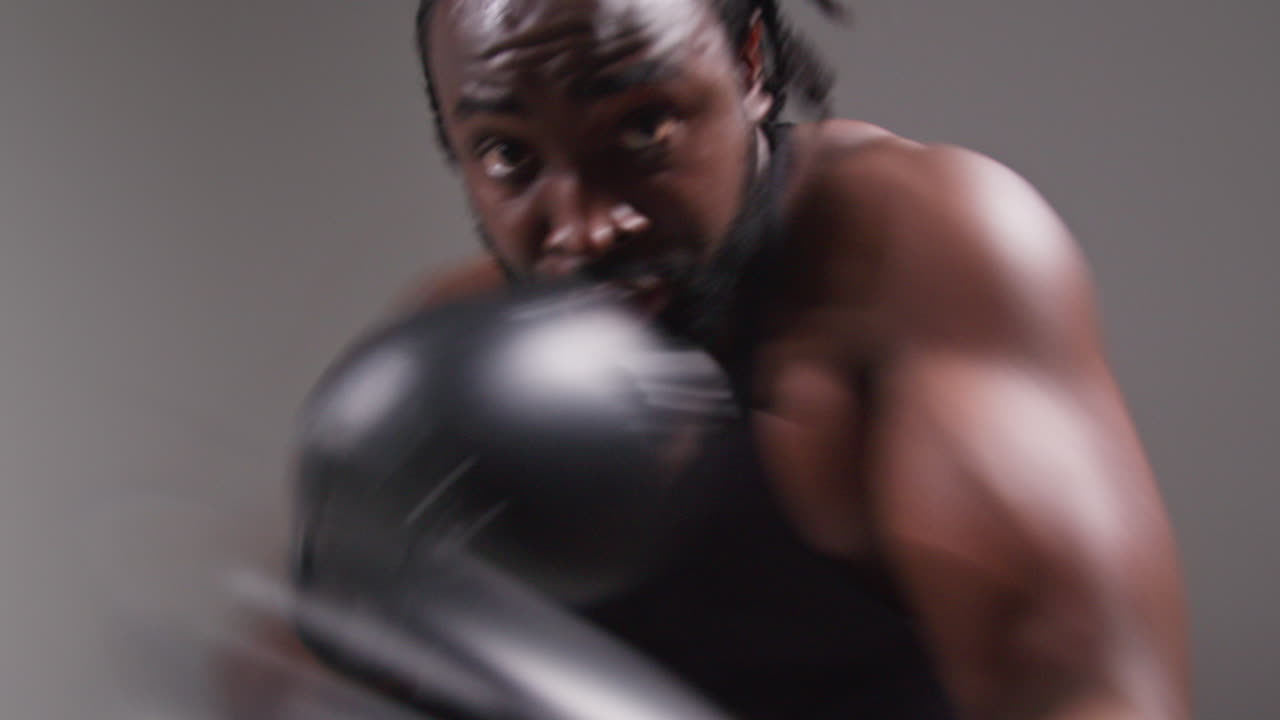 Real Time Studio POV Shot Of Male Boxer Wearing Boxing Gloves Training For Boxing Match In Gym Sparring And Punching Towards Camera