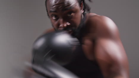 Echtzeit-Studio-POV-Aufnahme-Eines-Männlichen-Boxers-Mit-Boxhandschuhen,-Der-Im-Fitnessstudio-Für-Einen-Boxkampf-Trainiert-Und-In-Richtung-Kamera-Schlägt