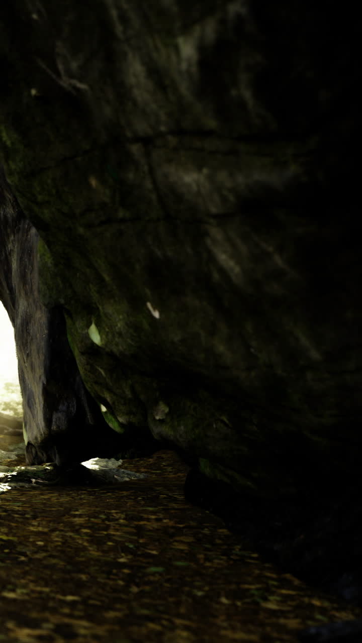 Esplorando una stretta apertura di grotta con luce che entra dall'esterno
