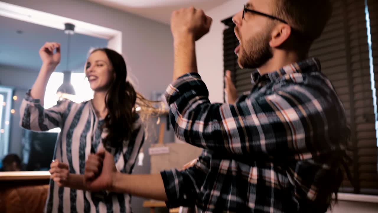 feliz joven trabajador independiente europeo disfruta bailando en una divertida fiesta corporativa en casa con amigos del lugar de trabajo en cámara lenta