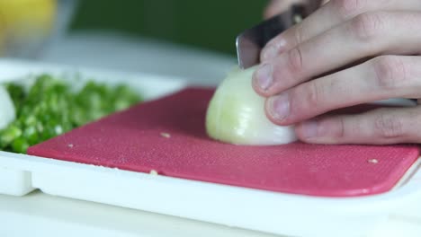 cortando cebollas en la tabla rosa
