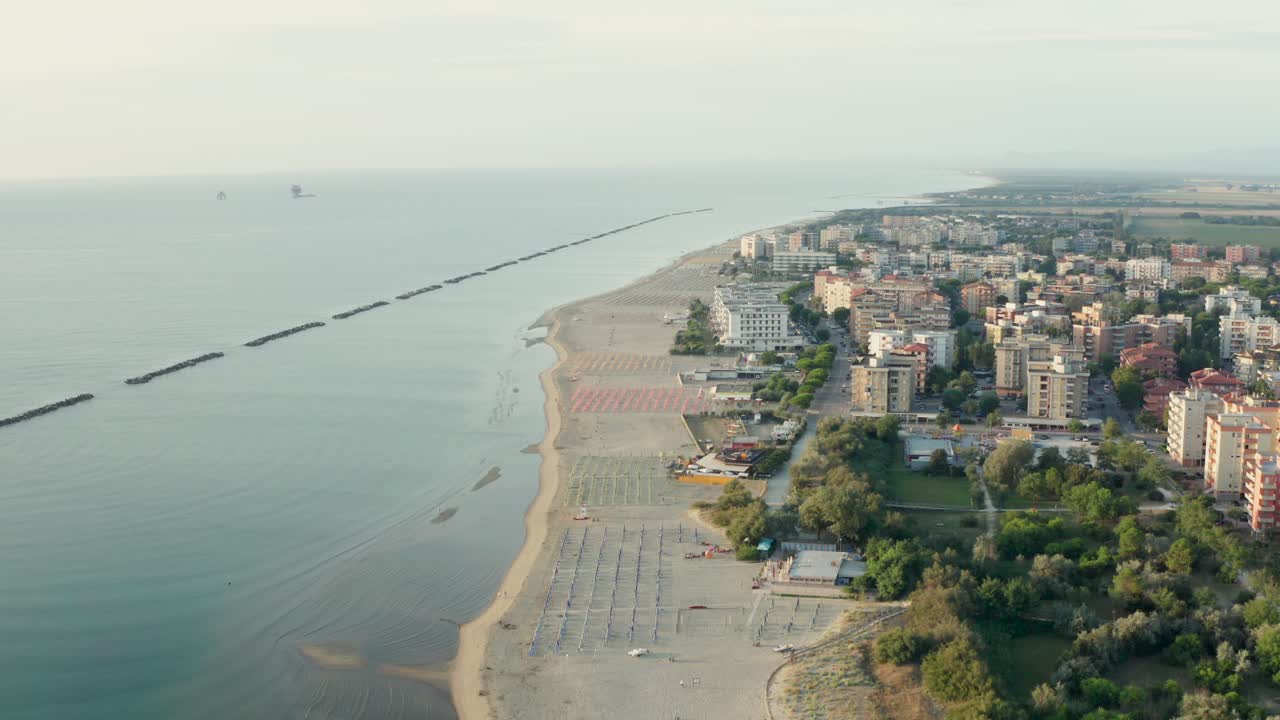 toma aérea de playa de arena con sombrillas y miradores