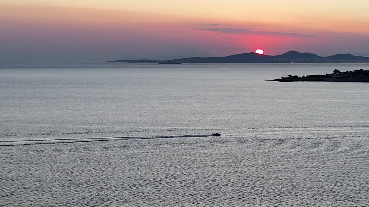 바다에서 일몰과 지나가는 스피드 보트 | 아테네 리비에라에서 일몰의 드론 영상