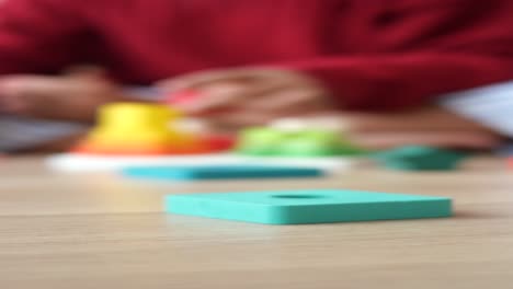 child playing with wooden puzzle pieces