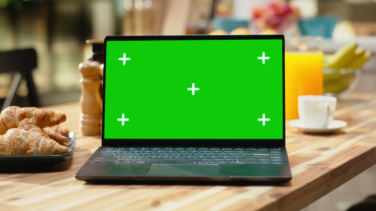 Laptop con green screen, interni di cucina rustica, tavolo da colazione in legno