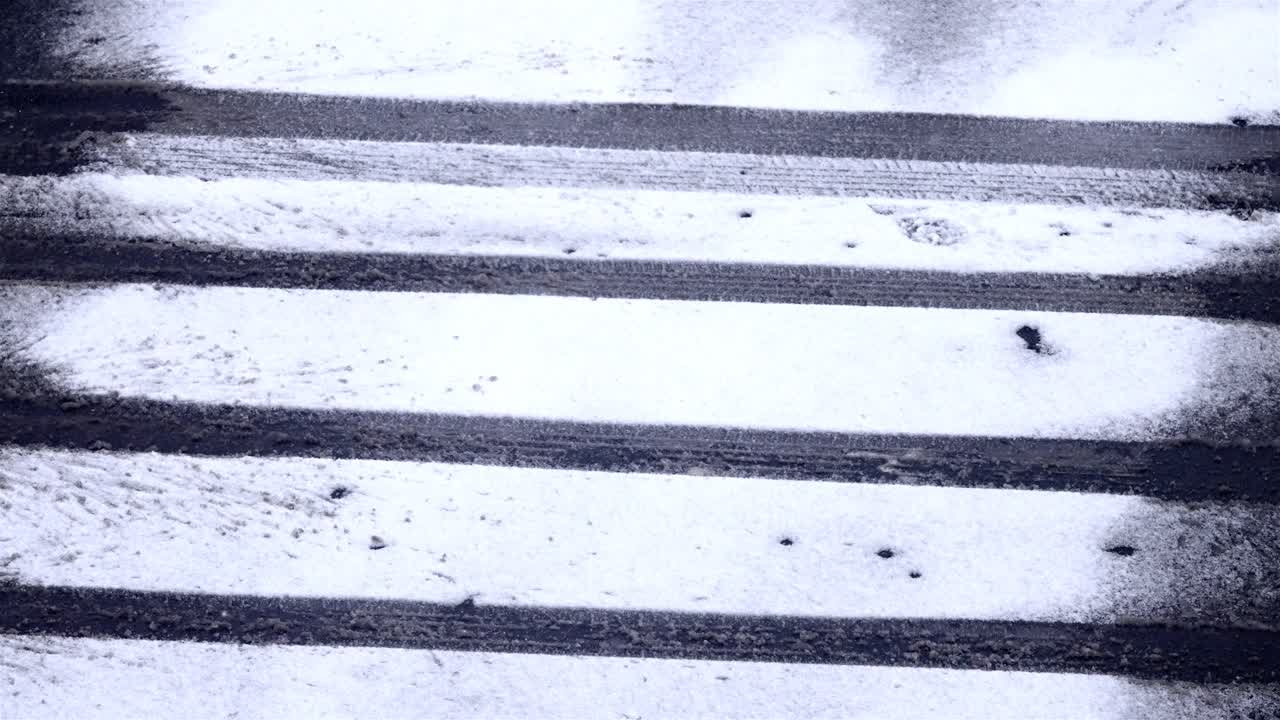 Car wheel pattern in the snow on the street, light snowfall on the road on a cold winter day, static shot, copy space