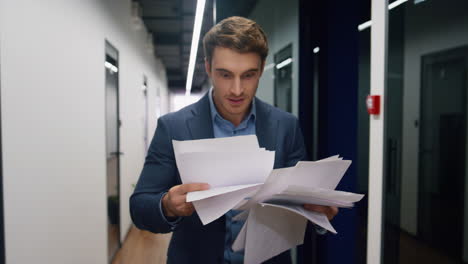 successful employee throwing papers in hallway. happy businessman celebrating