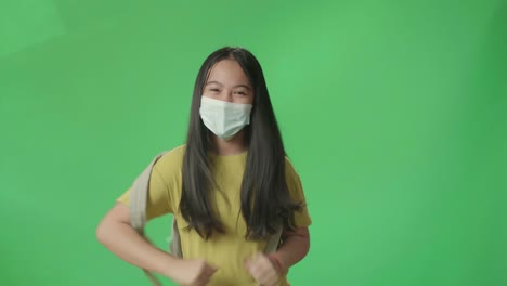 asian girl student wearing mask and running to school on green screen chroma key