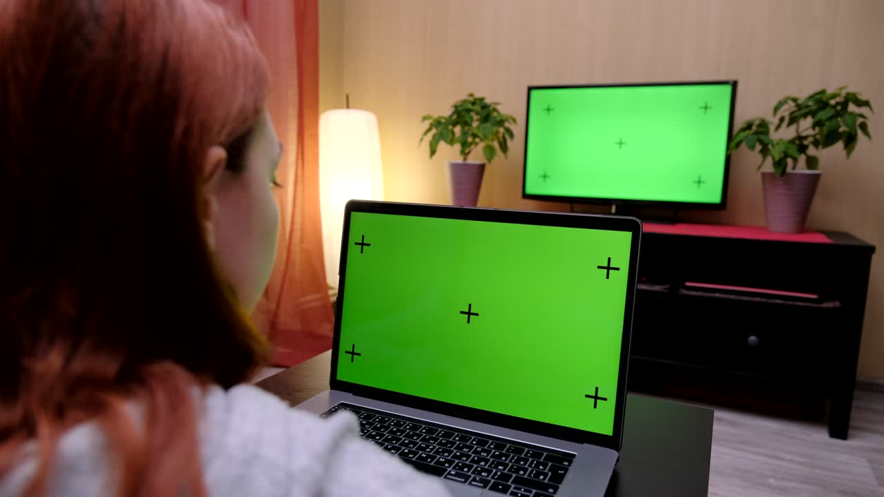 mujer con pantalla verde. mujer mira televisión y usa computadora con pantalla verde