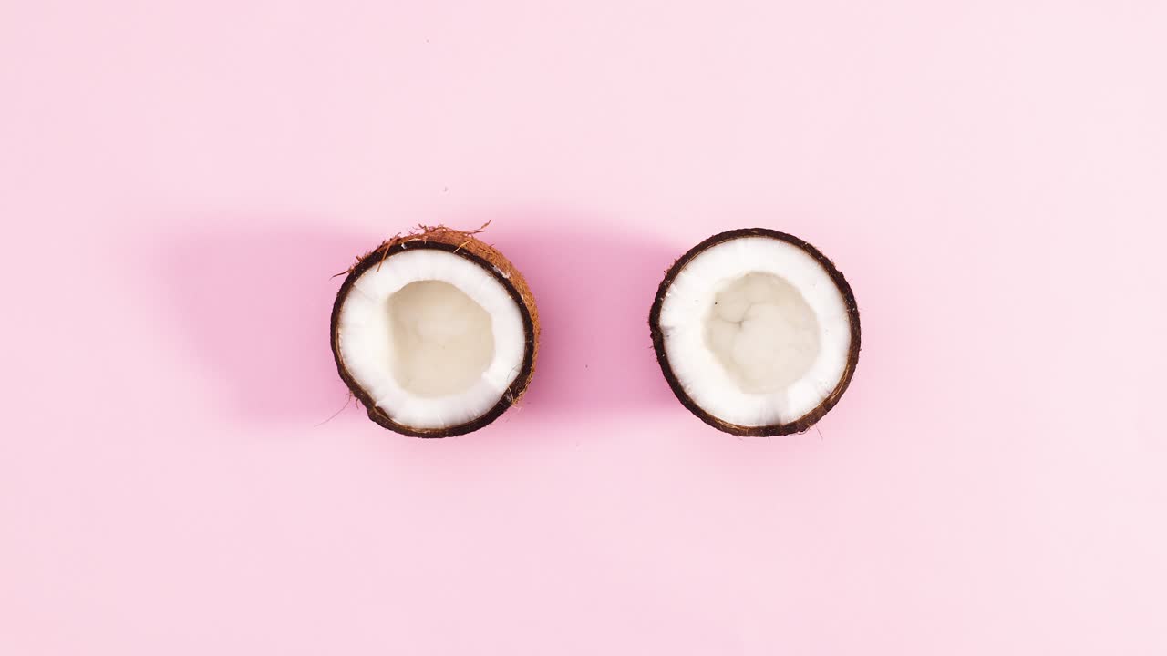 Two half of coconut rotate on pastel pink theme. Stop motion