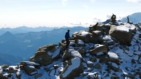 Hiker-climbing-and-arriving-on-top-of-mountain-of-Cima-Fontana-in-Valmalenco,-Italy