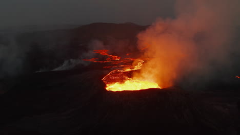 Slide-and-pan-footage-of-active-volcano.-Aerial-view-of-boiling-magma-in-crater-and-flowing-molten-lava-on-ground.-Fagradalsfjall-volcano.-Iceland,-2021