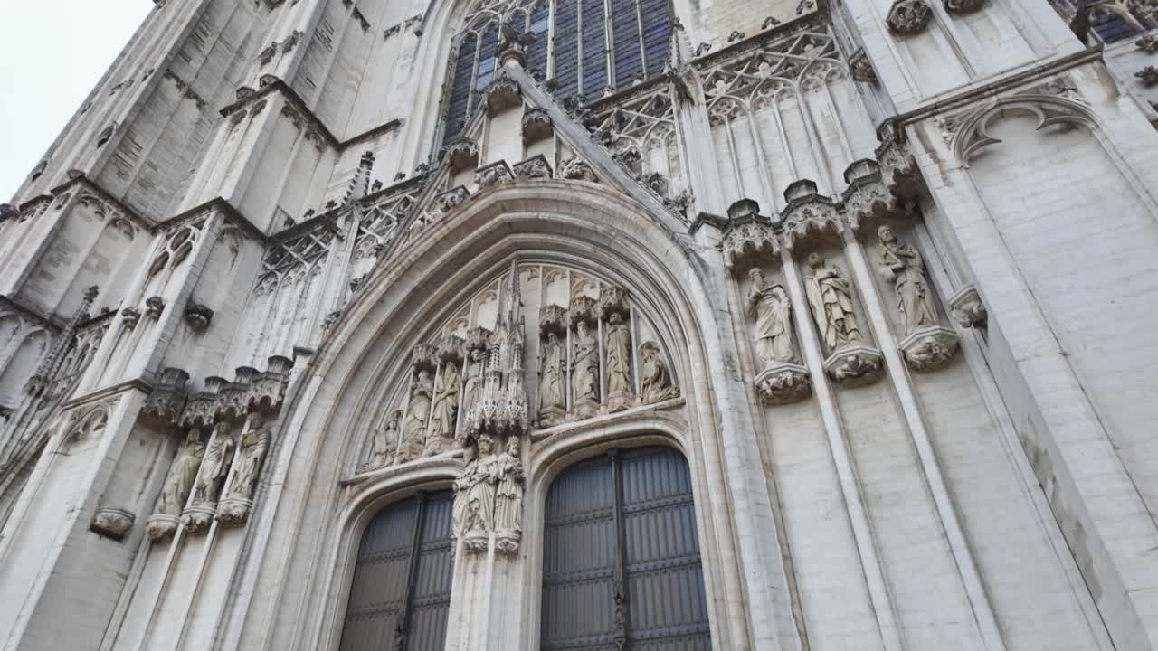 Low angle view of the intricate Gothic facade of St Michael and St Gudula Cathedral in Brussels, showcasing its detailed stonework and towering spires