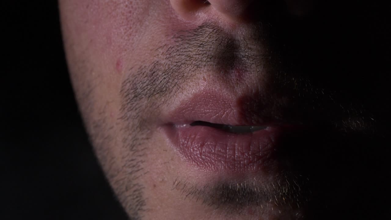 macho joven adulto con rastrojo closeup fumar cigarrillo en negro oscuro fondo studio