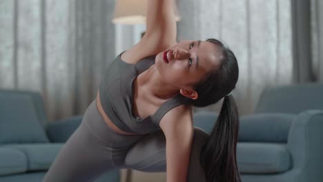 retrato de cerca de una joven atleta asiática haciendo ejercicio, estirándose y practicando yoga en casa. estilo de vida saludable, fitness, bienestar y concepto de atención plena