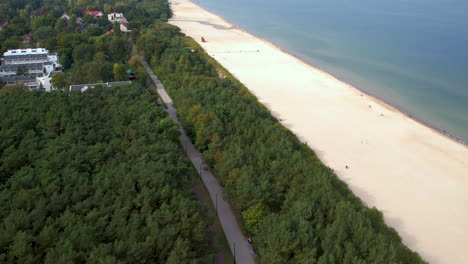 Panorámica-Aérea-Del-Sendero-Para-Caminar-Y-Andar-En-Bicicleta-Paralelo-A-La-Playa-De-Gdansk-Jelitkowo-Polonia