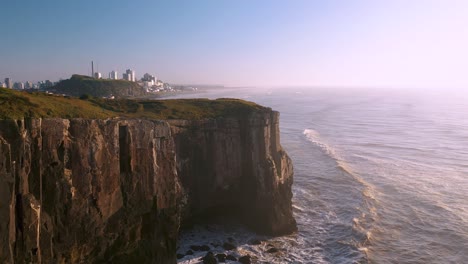 Toma-Cinematográfica-Aérea-De-Drones-De-Altos-Acantilados-Rocosos-En-El-Océano-Atlántico,-Ubicado-En-Torres,-Rio-Grande-Do-Sul,-Brasil