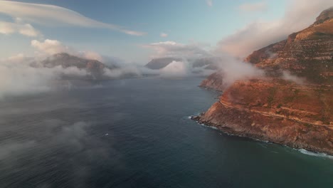 Ciudad-Del-Cabo,-Sudáfrica---Una-Vista-Impresionante-De-Noordhoek-Y-Chapman&#39;s-Peak-Drive-Durante-La-Puesta-De-Sol---Toma-Aérea-De-Drones