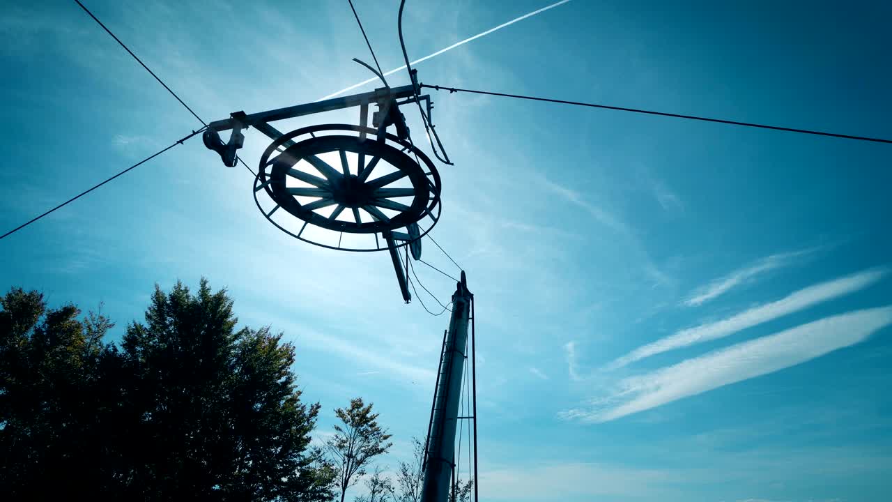 detalle de la rueda de elevación de esquí y los cables contra el sol y el cielo azul