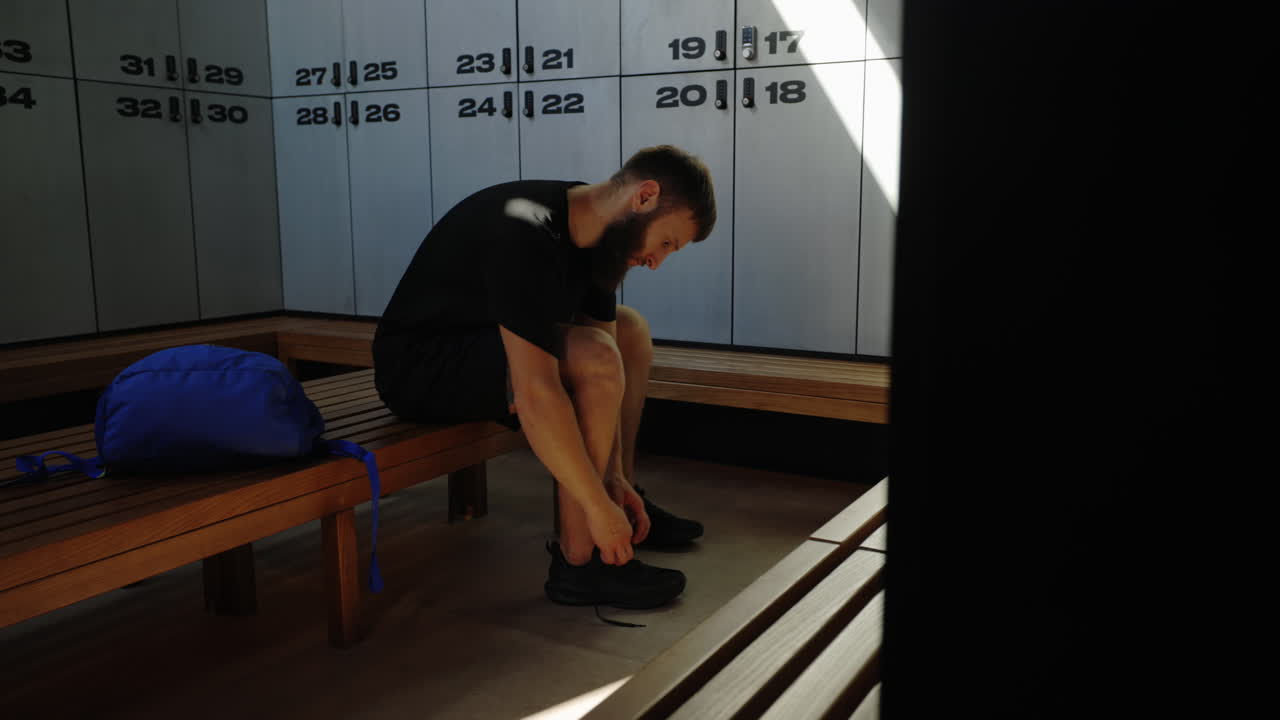 Man tying shoes in a locker room