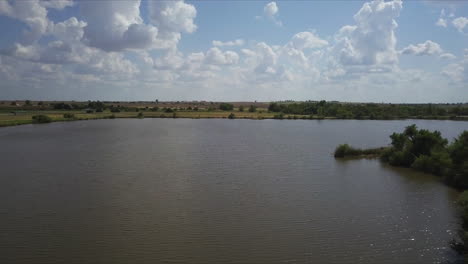 Backward-revealing-shot-of-a-large-open-lake-and-surrounding-forest