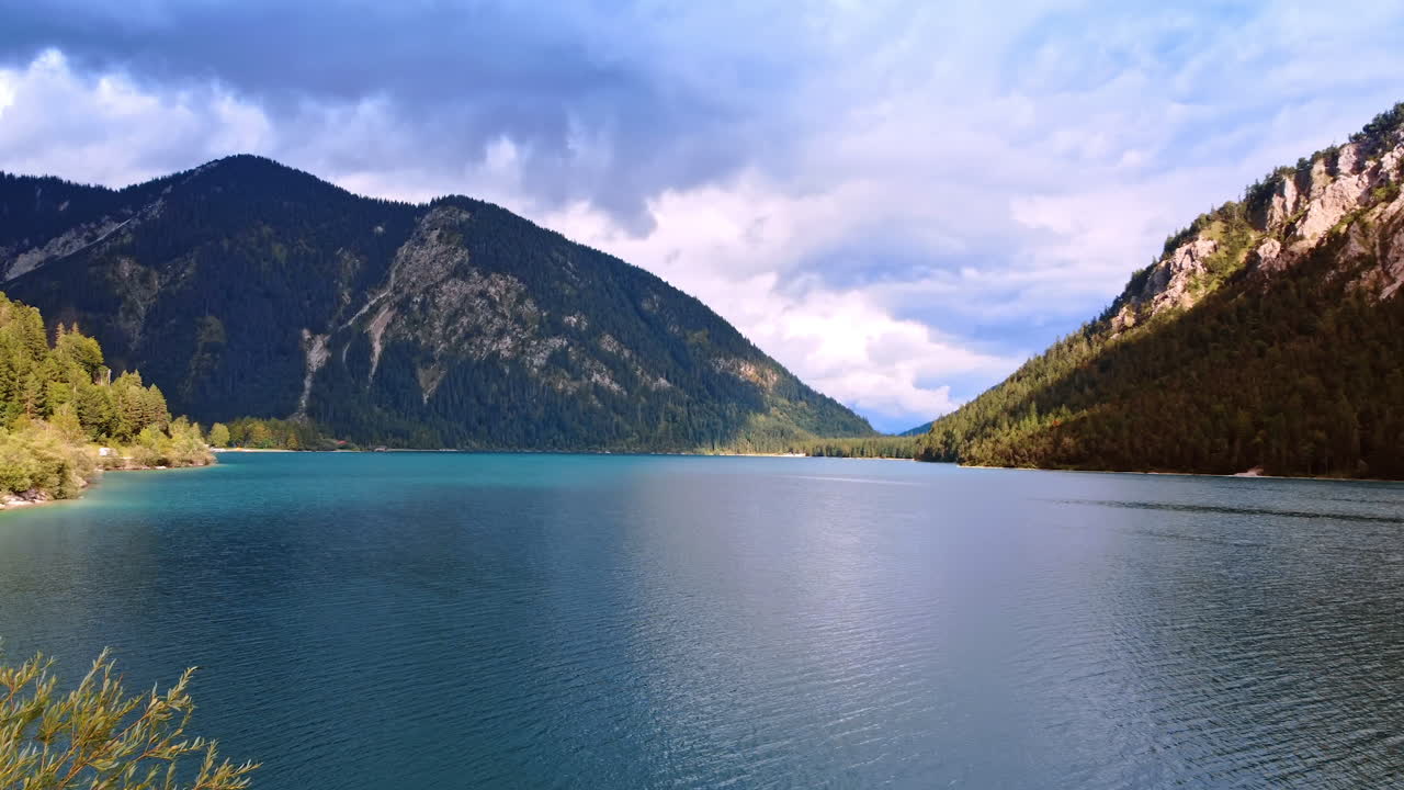 Footage over the waterscape among the beautiful mountains covered with pine trees. Wild nature of Lichtenstein, Europe.