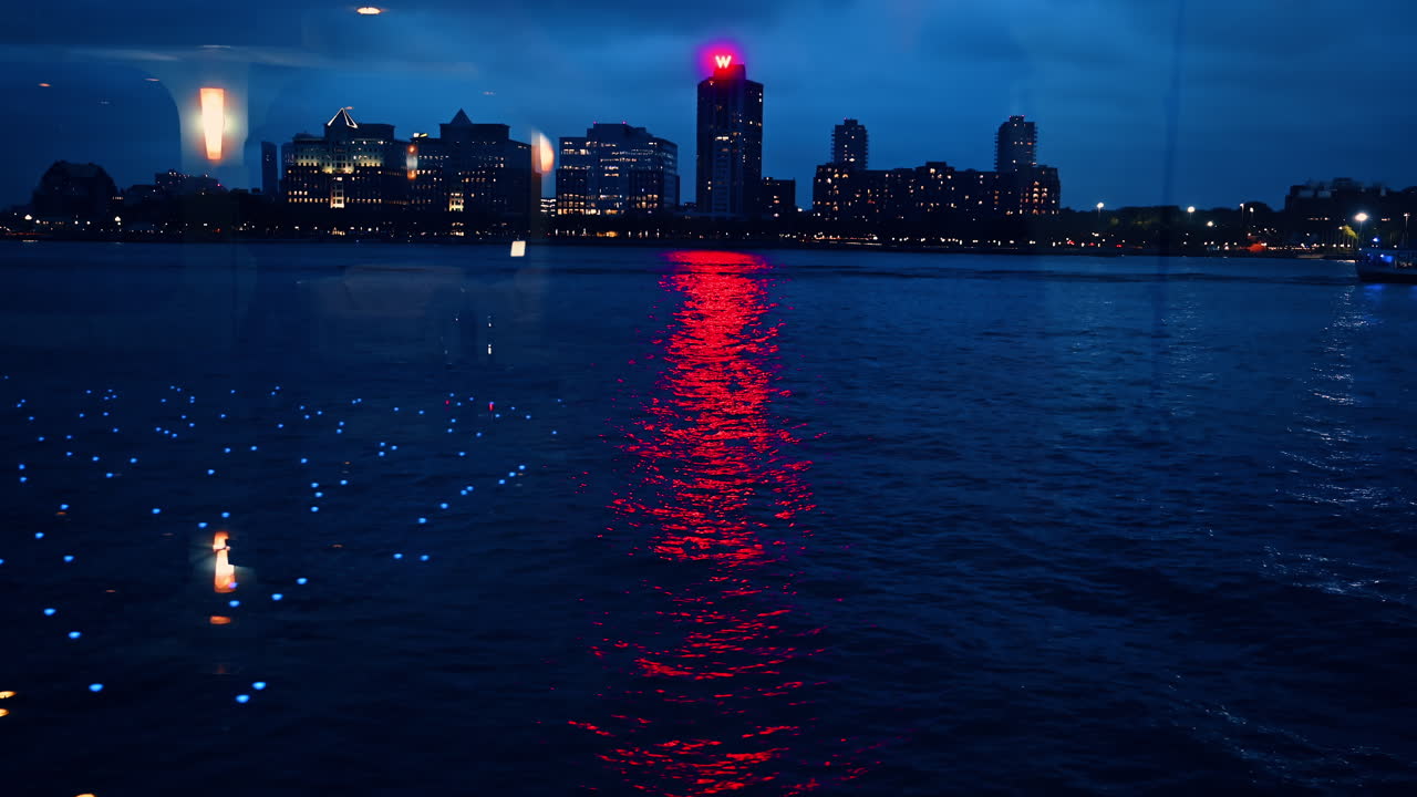 New York, USA, 24. august 2025: Natlige refleksioner på Hudson River. Røde og blå bylys reflekteres i Hudson River om natten