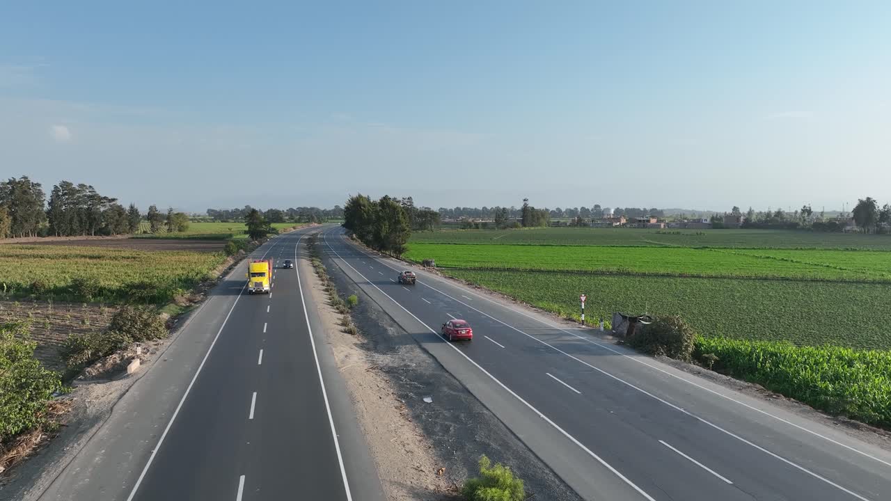 페루의 아름다운 다차선 파나메리카나 노르테 고속도로를 타고 양쪽 모퉁이에 있는 농지를 통해 자동차를 따라가는 드론