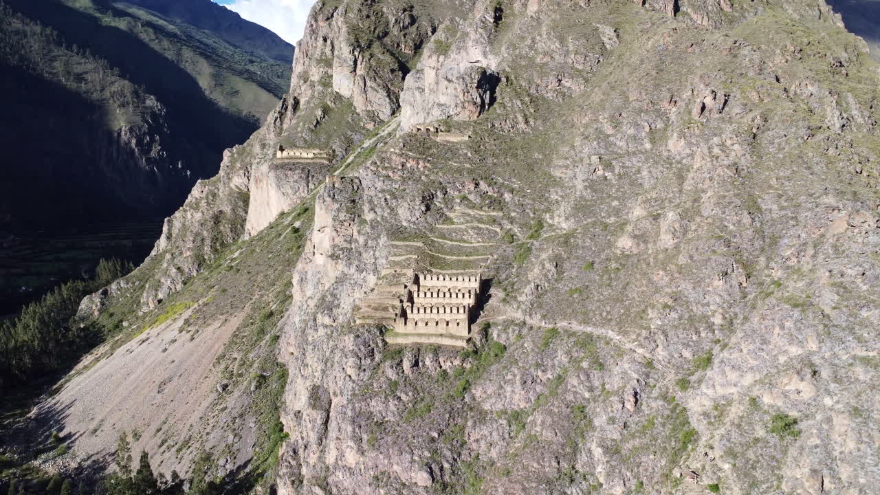 panorámica panorámica de ángulo alto del sitio histórico de la ciudad de ollantaytambo cortado en la ladera de la colina en perú