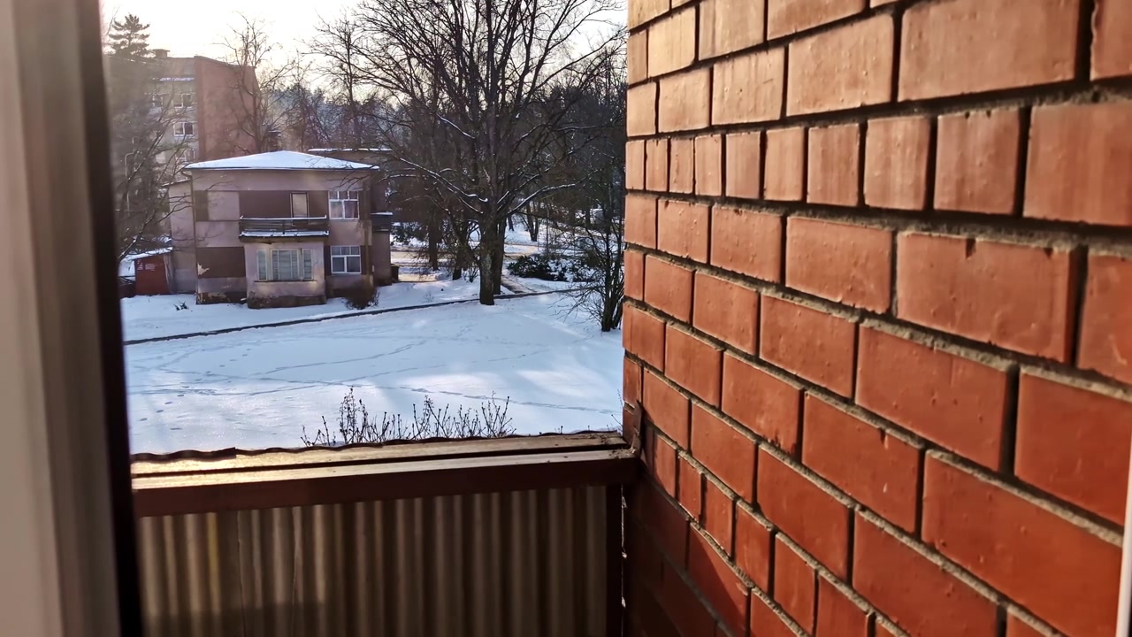 Personal perspective from balcony looking at a snowy yard and soviet era buildings