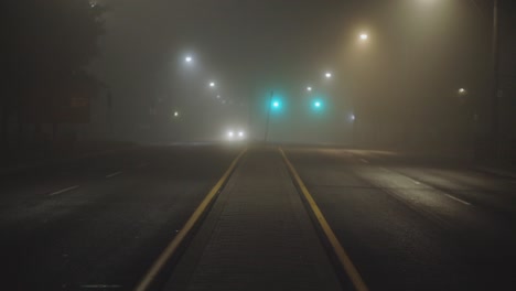 Bright-Headlights-Of-A-Car-Driving-On-Foggy-Road-At-Night---wide