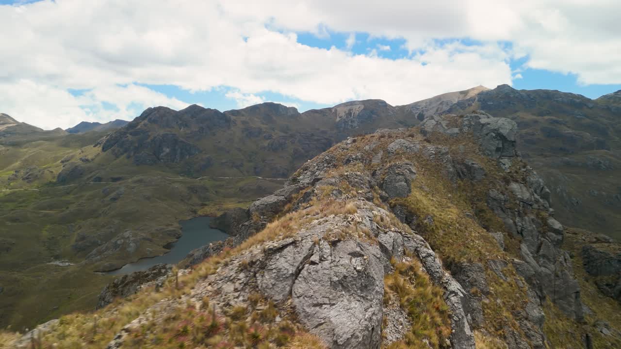 Clip video cinematica e dinamica realizzata con drone a bassa quota e vicino a una scarpata montuosa impervia, che rivela ripide scogliere rocciose e la tundra paramo ad alta quota sulle Ande ecuadoriane.