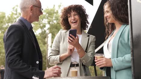 happy business people talking while having coffee in city