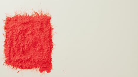 video of square of red coloured powder with copy space on white background