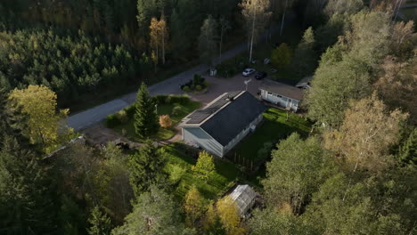 aerial orbit shot of a house powered by sunlight collectors, autumn evening