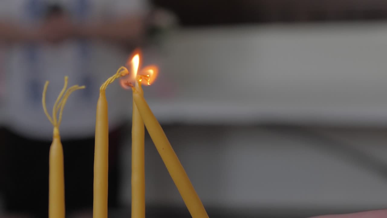 encendiendo velas amarillas en la iglesia. tiro en cámara lenta