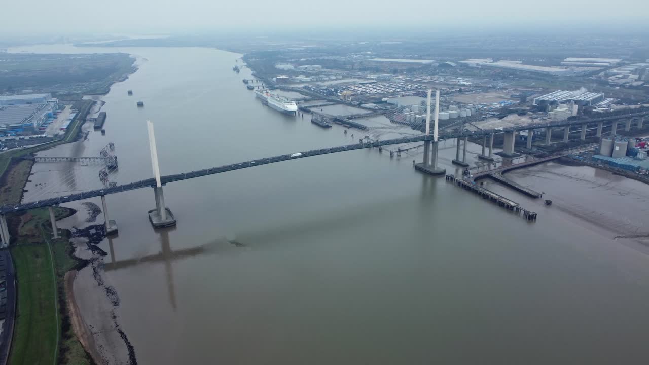 Aerial view of a cable-stayed bridge over a river in an urban area