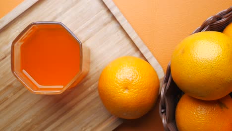 Orangensaft-In-Ein-Glas-Auf-Einem-Hintergrund-Gießen,