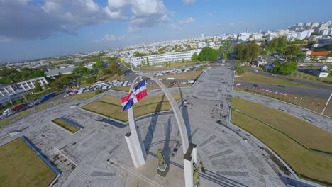 Aerial-drone-FPV-flying-around-triumphal-arch-in-plaza-de-la-Bandera,-Santo-Domingo-town-center-in-Dominican-Republic