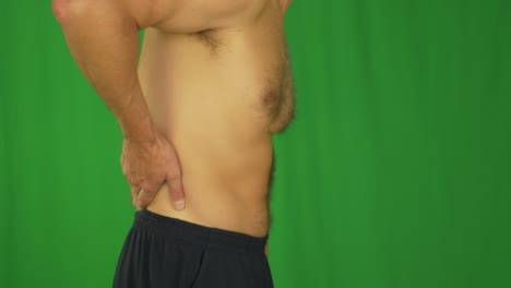hombre frotando la espalda baja con las manos. vista de perfil lateral de cerca.