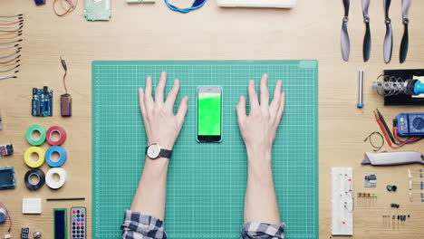 Top-view-software-engineer-using-smartphone-touchscreen-at-desk-from-above---Red-Epic-Dragon