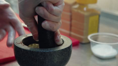 cook prepares the seasoning for the salad in a mortar 1